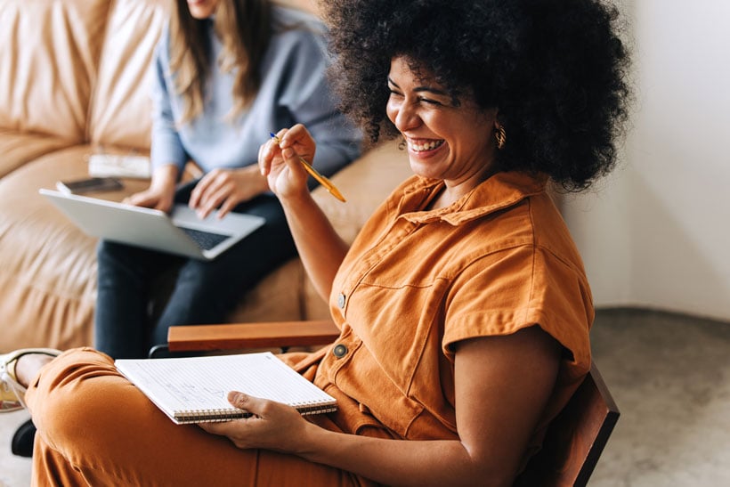 A woman loaughing at work - Pearson TalentLens
