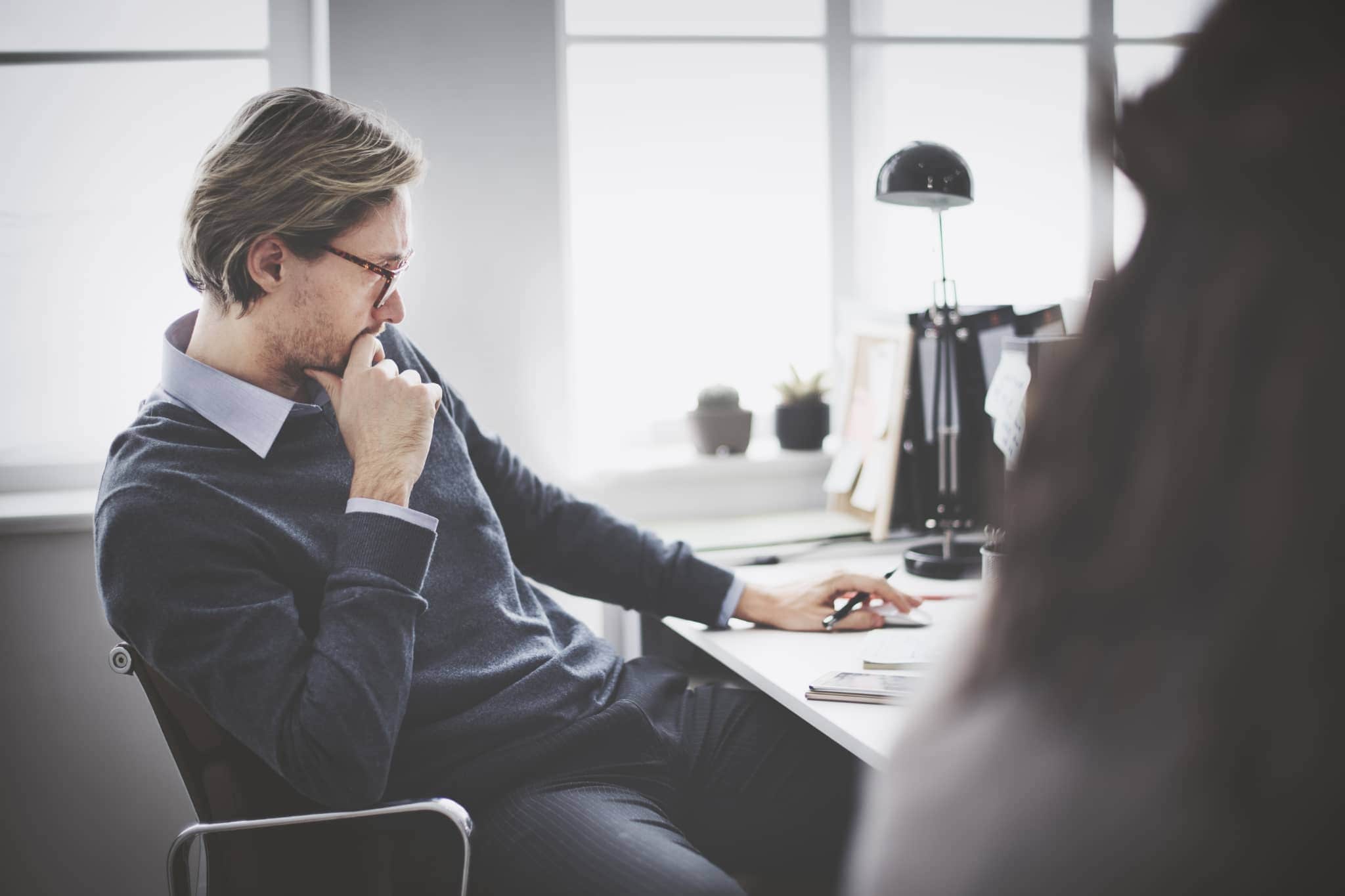 A male worker working at a desk  - Pearson TalentLens