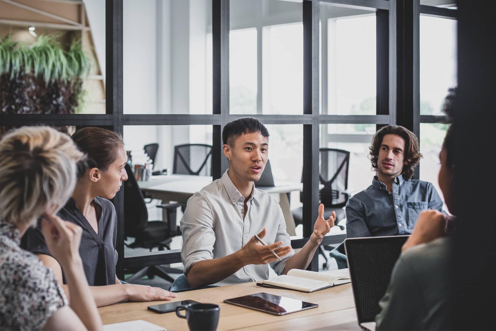 A group of coworkers discussing - Pearson TalentLens