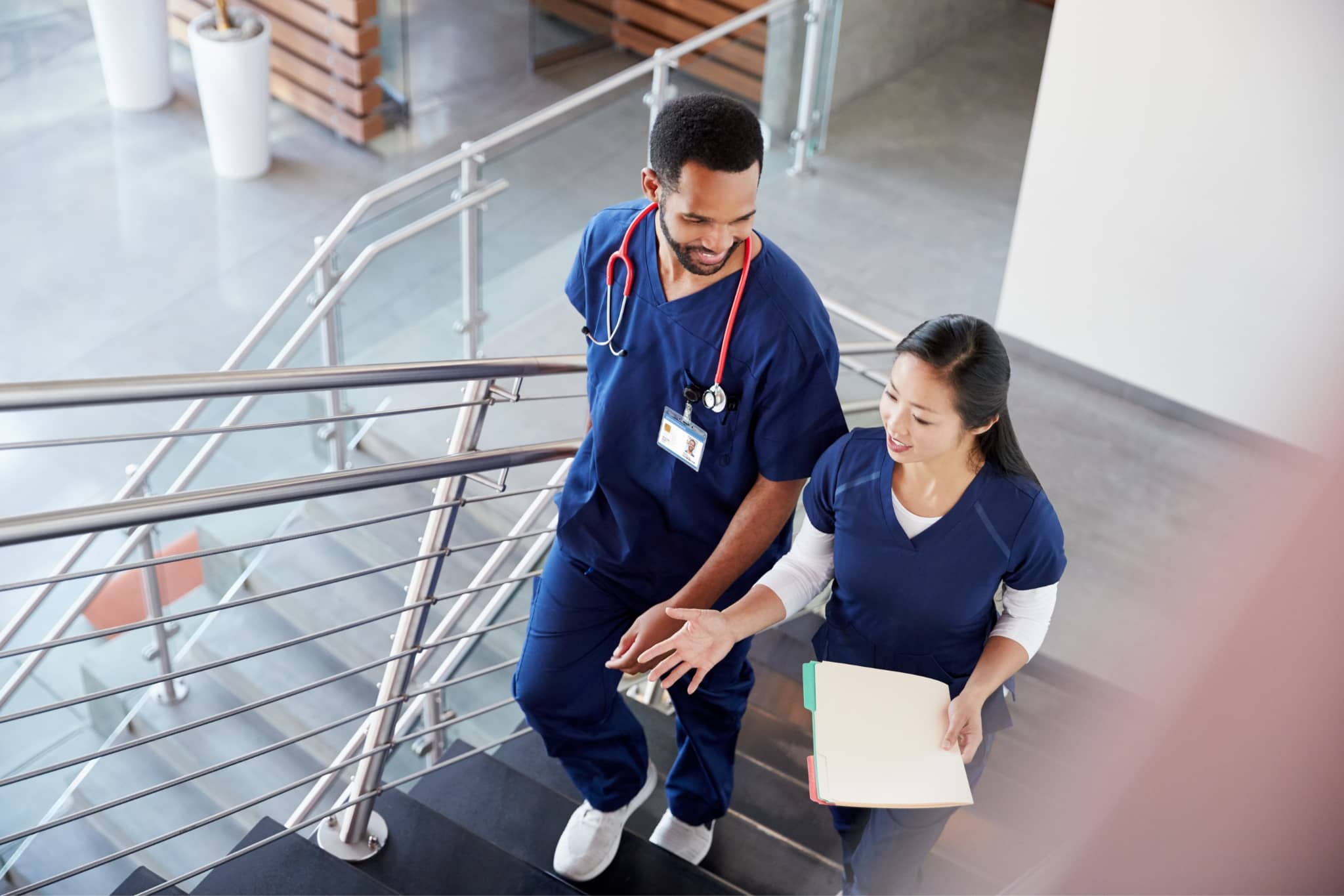 Two doctors chatting in a hospital staricase - Pearson TalentLens