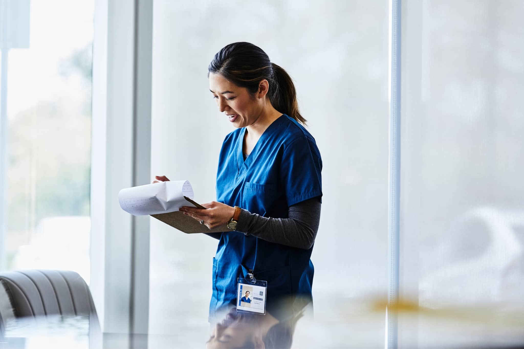 A female doctor writing on a pad - Pearson TalentLens