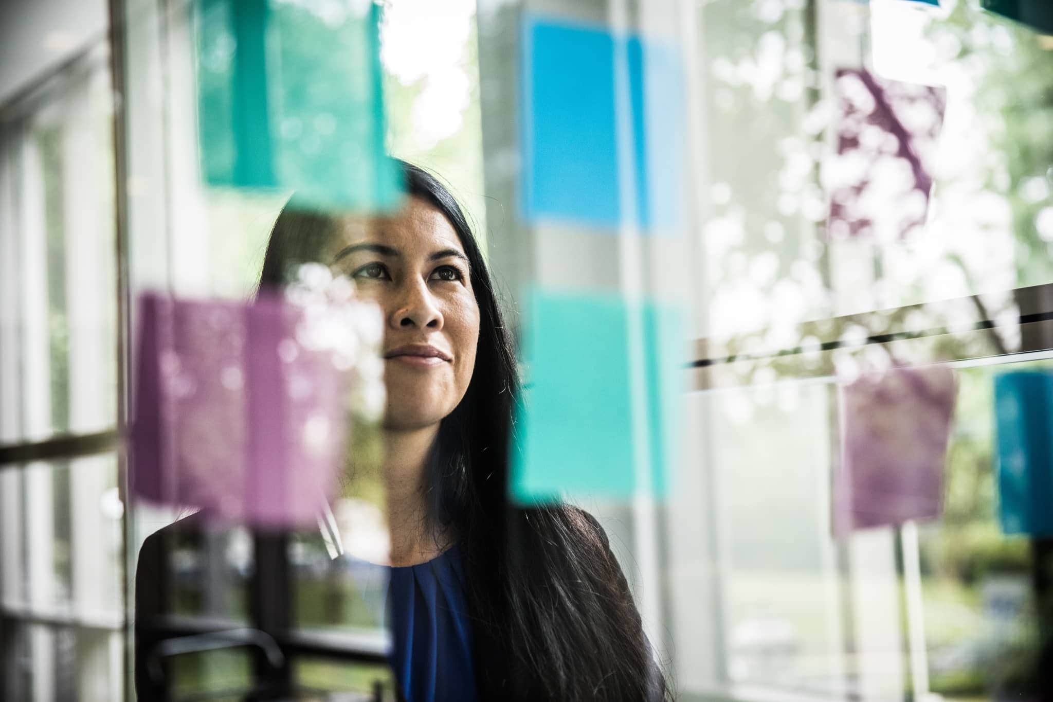 A female worker looking at post-its - Pearson TalentLens