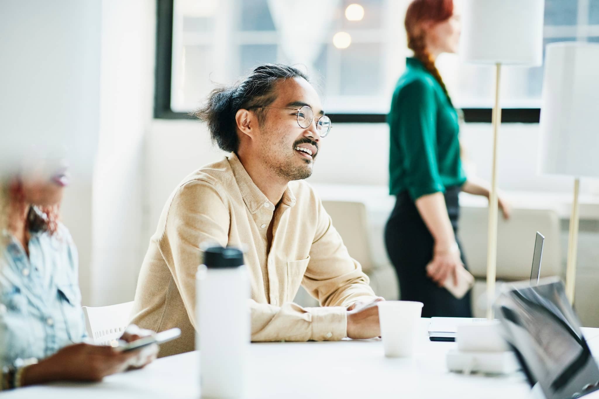 A male worker at the office listenning to a colleague - Pearson TalentLens