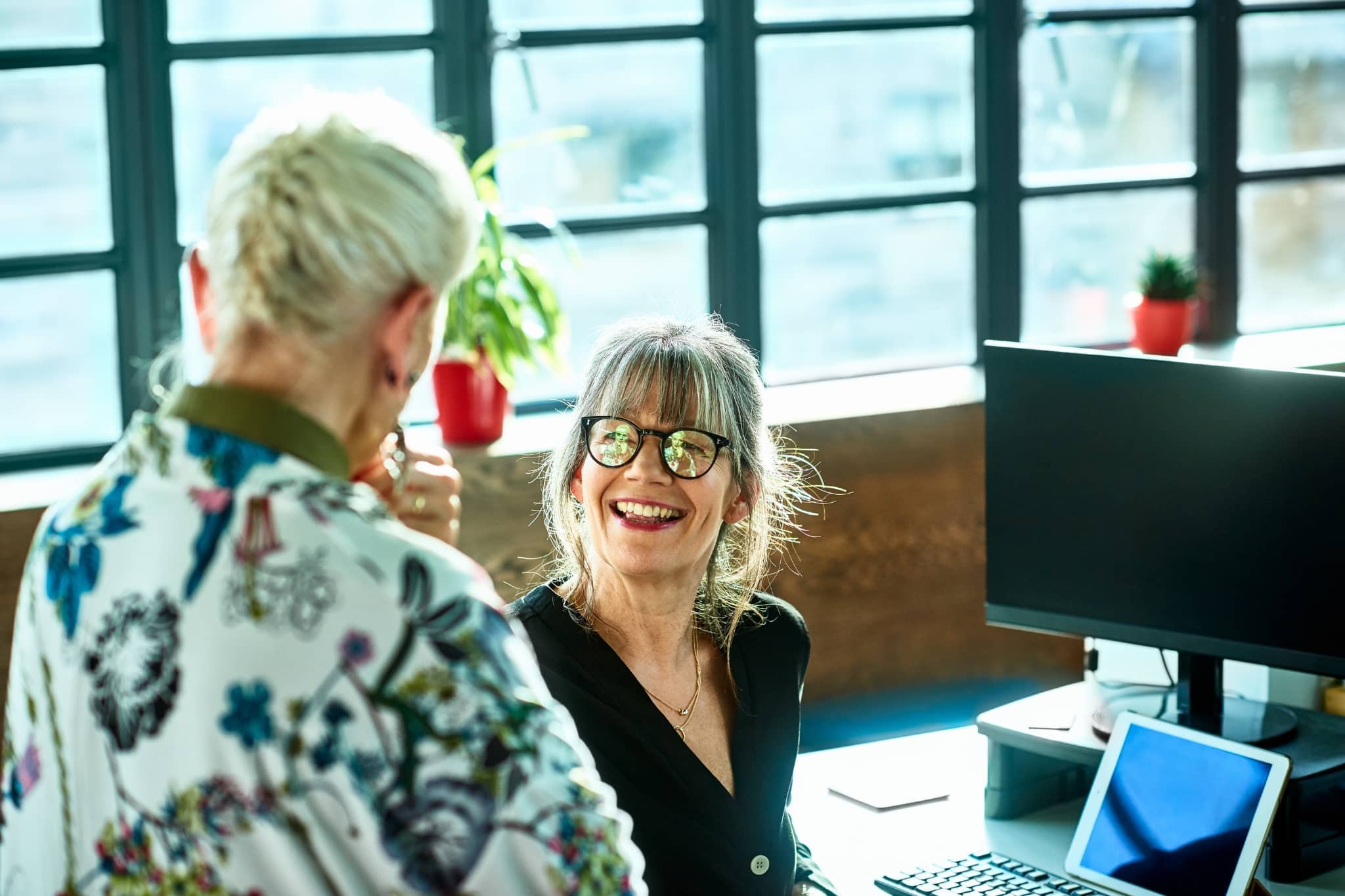 2 female workers discussing - Pearson TalentLens