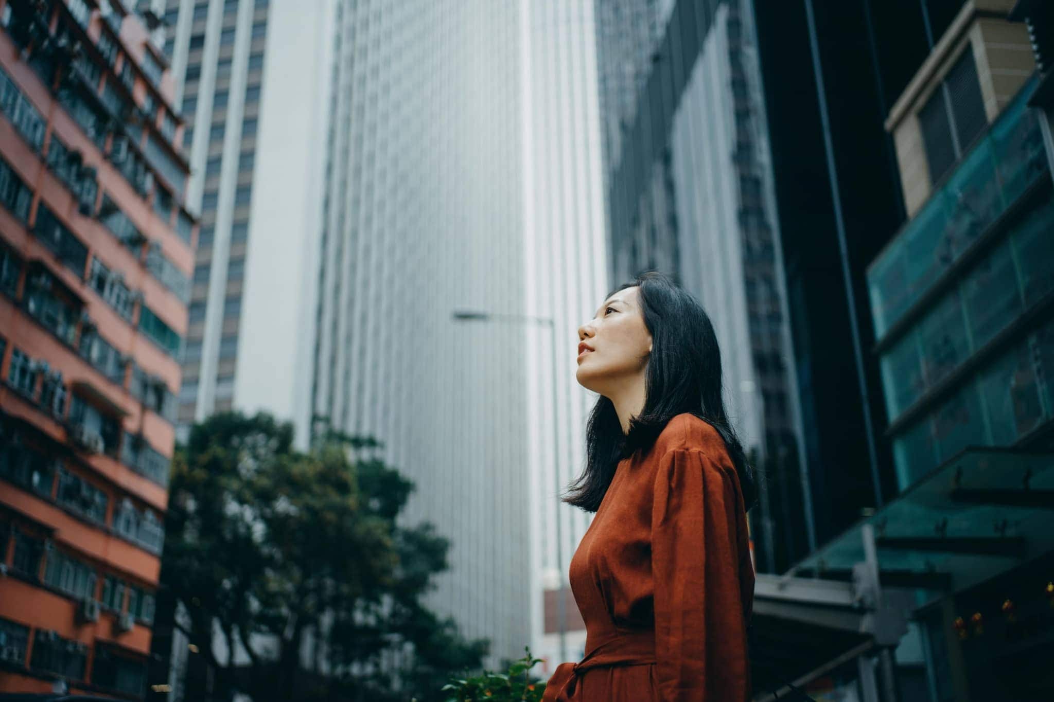 A woman on the street looking at the sky - Pearson TalentLens