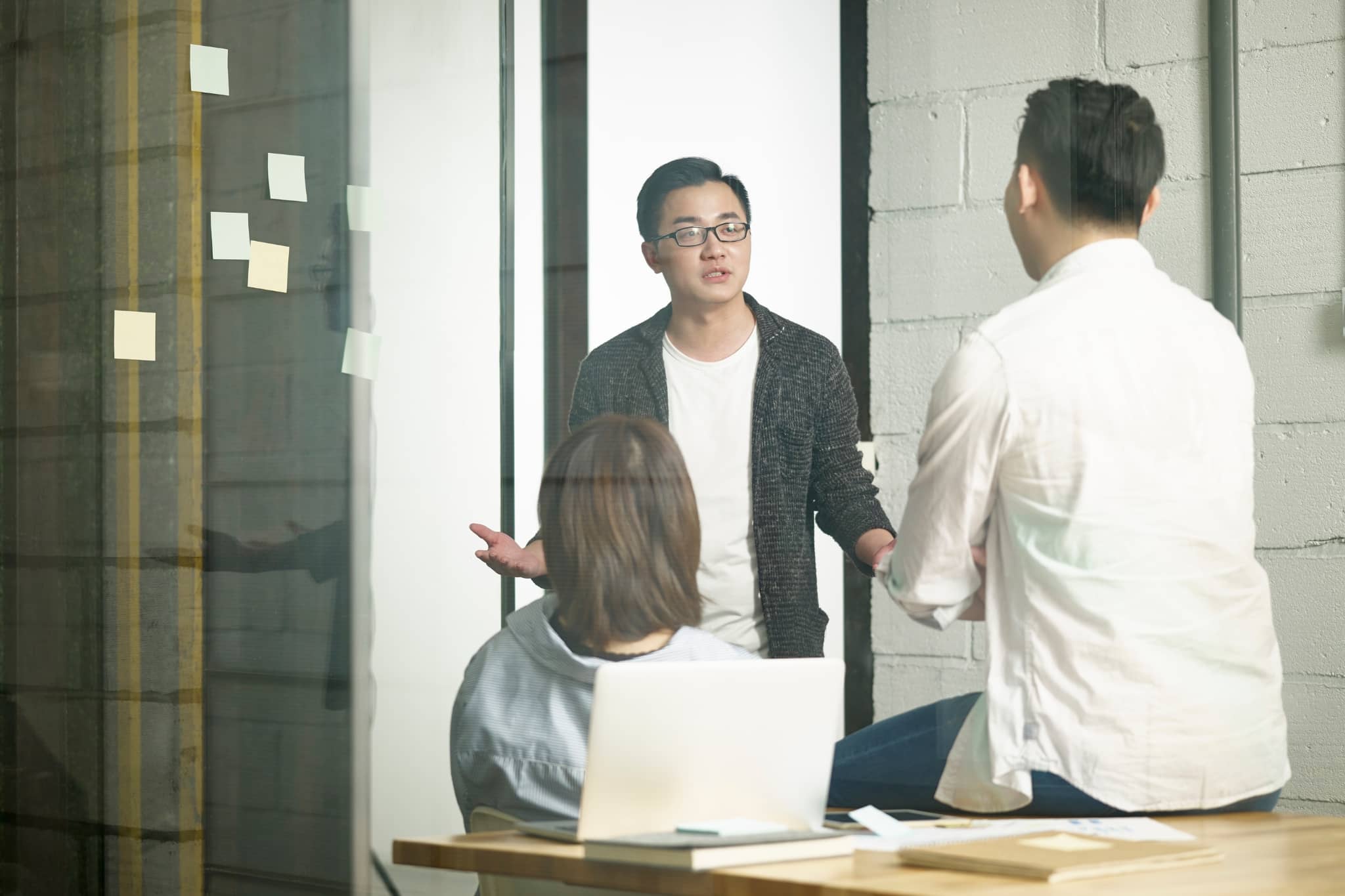 A male worker discussing with team members - Pearson TalentLens