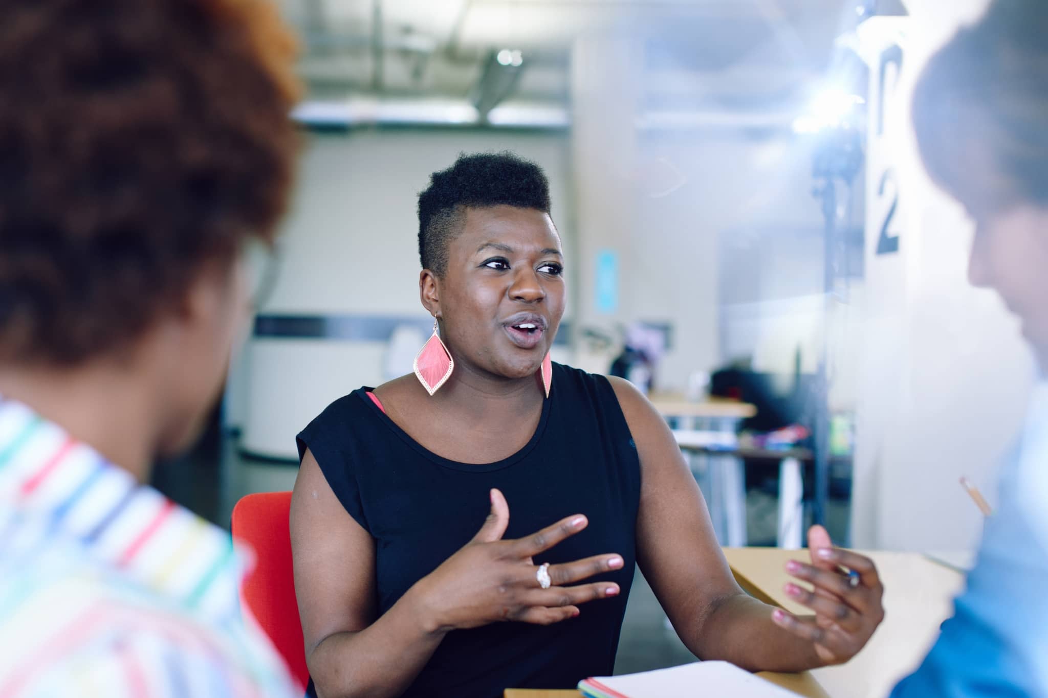 A female worker  chattingwith coworkers - Pearson TalentLens