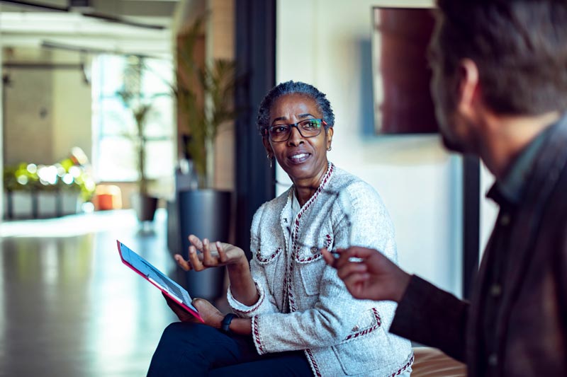 Two workers discussing at work - Pearson TalentLens