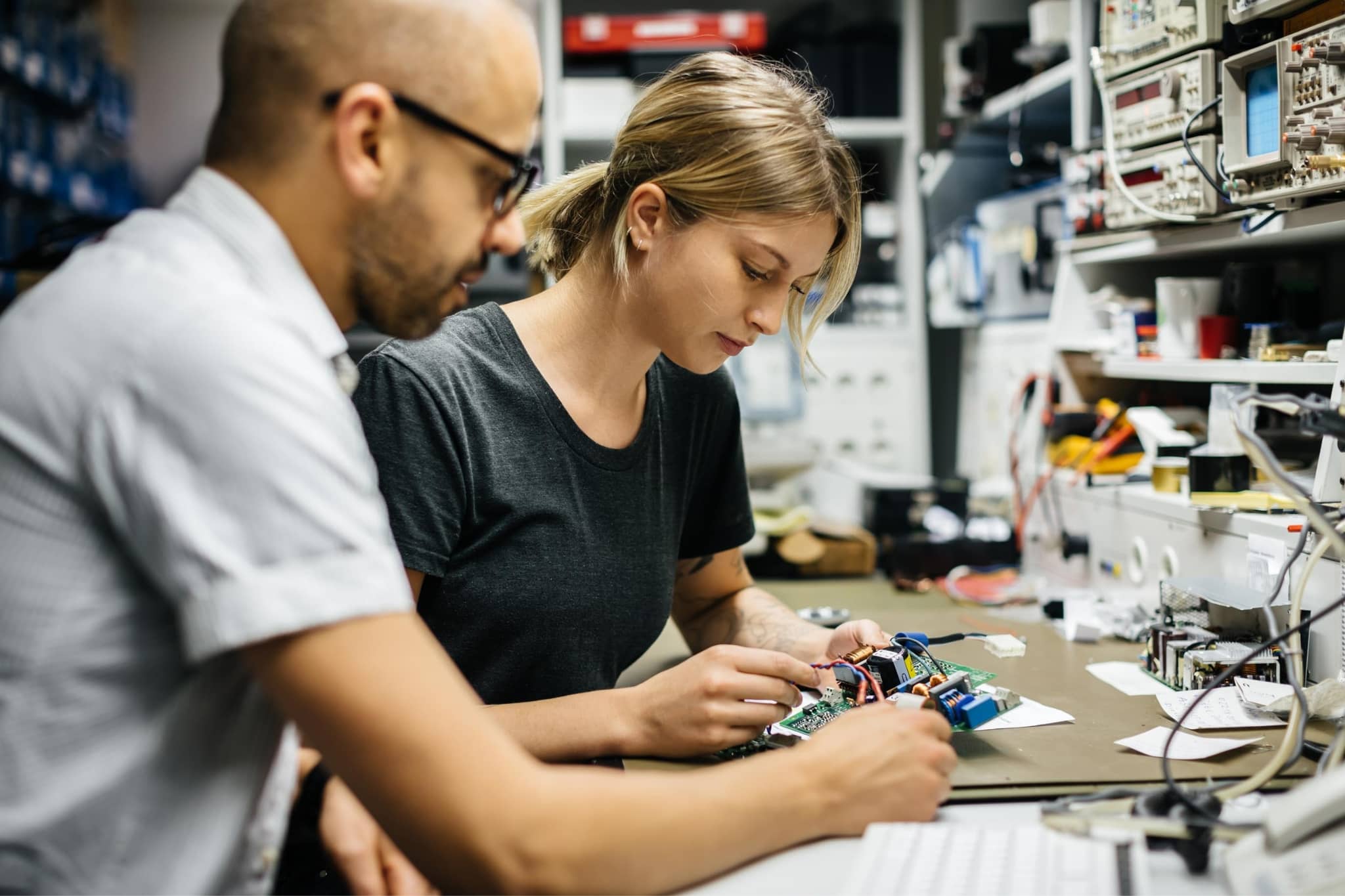 Two engineers working an electric machine -  Pearson TalentLens