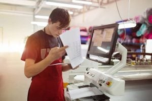 Manufacturing industry - person studying orders at machine - Pearson TalentLens