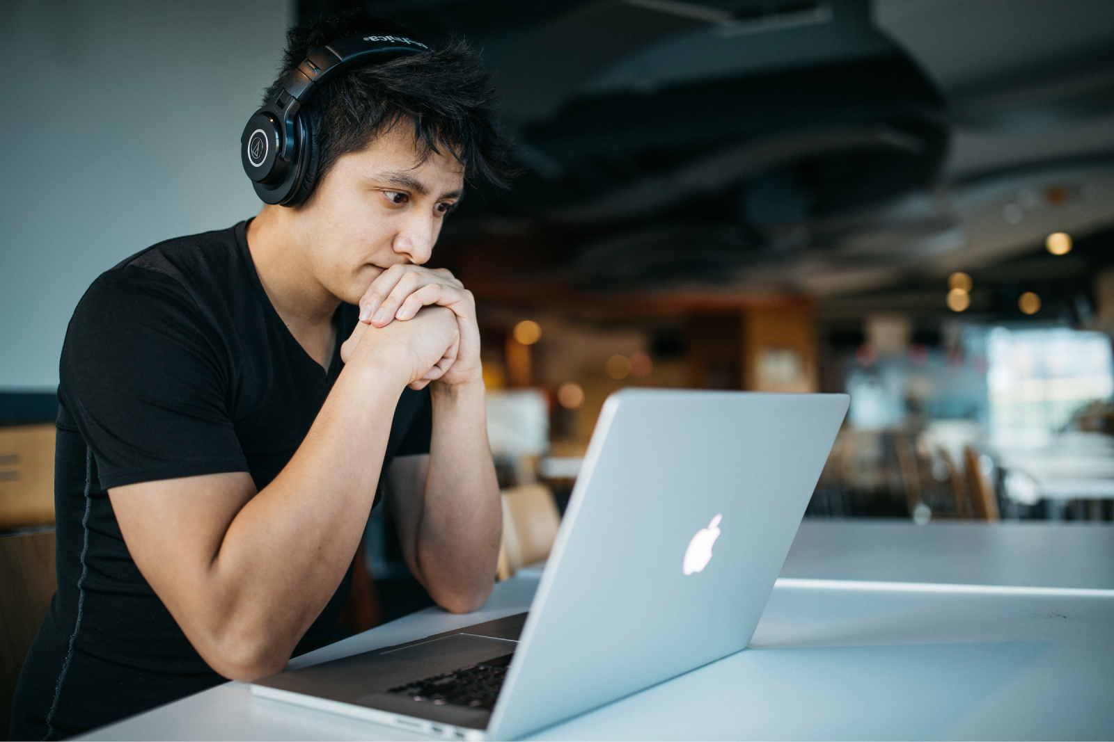 Recruitment - man looking at laptop with headphones on - pearson TalentLens